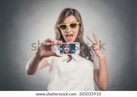 Young woman taking self portrait showing peace sign