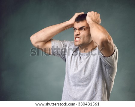 Man holding his head and shouting in anger