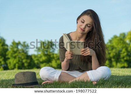 Beauty young woman with book in park