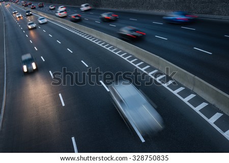 Traffic in motion on highway at dusk