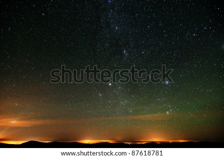 Part of Milky way over city lights and mountains natural photo