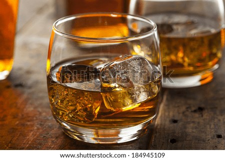 Alcoholic Amber Whiskey Bourbon in a Glass with Ice