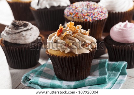 Assorted Fancy Gourmet Cupcakes with Frosting on a Background