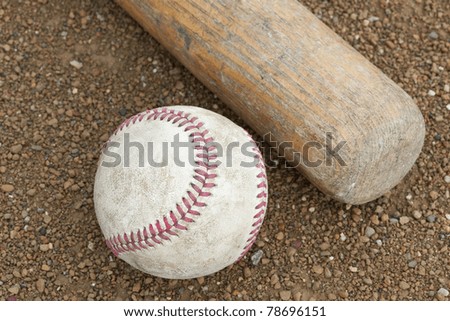 A baseball bat and ball in a baseball diamond