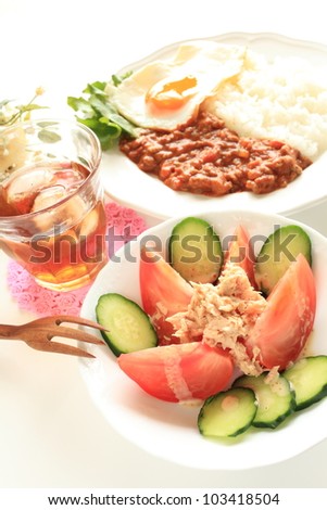 Tuna fish and tomato salad with curry rice on background