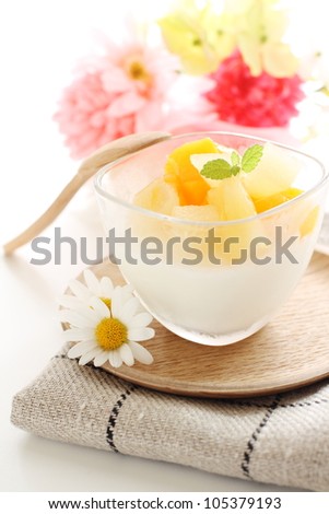 Gourmet dessert, Almond pudding with cut fruit and flower on white background