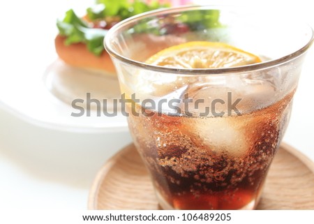 Cola with ice in glass close up with bubbles soda
