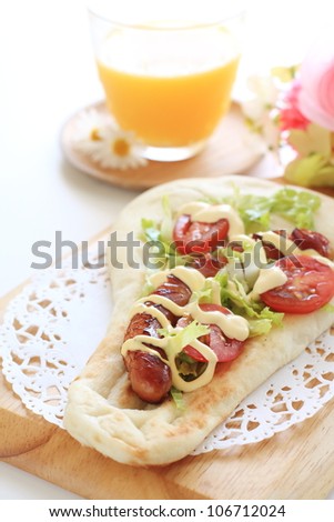 Japanese fusion food homemade sausage on nann, nann dog and orange juice
