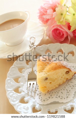 English milk tea and piece of cake with elegant flower on background