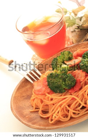 italian cuisine, bacon and broccoli spaghetti on wooden plate with iced tea for cafe food image