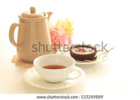 Black tea and chocolate tart with tea pot for afternoon tea image