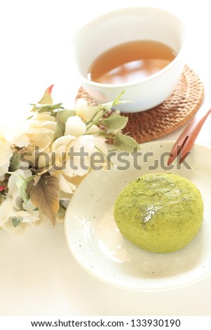 japanese cuisine, green tea mochi on dish and tea with flower on background