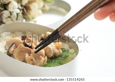 Japanese packed lunch, steamed mushroom and chicken on rice with chopstick for dining image