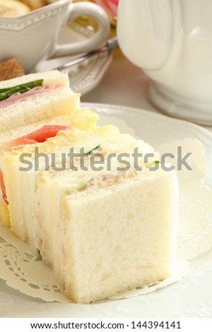 assorted sandwiches in square size and lemon tea