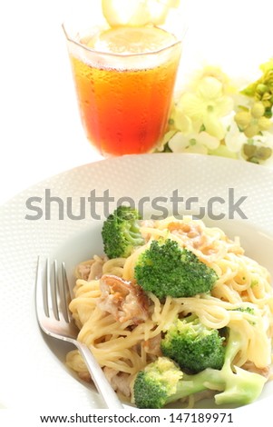 italian food, broccoli and pork spaghetti with lemon tea on white background