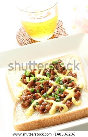 Japanese fusion food, Natto and mayonnaise on toast with green tea and flower on background