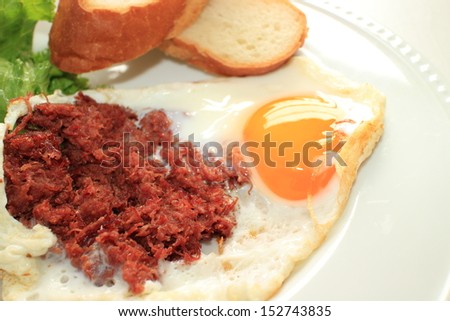 Corn beef and sunny side up egg with french bread for gourmet breakfast image