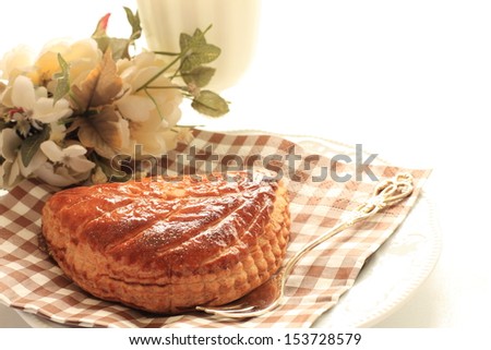 home bakery meat pie on paper napkin with flower and glass of milk on background,