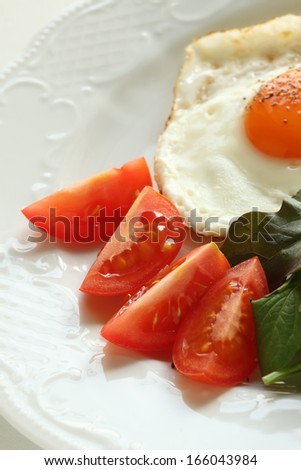 close up of chopped tomato with sunny side up on side for healthy breakfast image