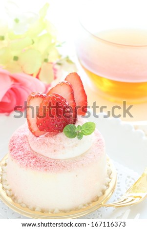 Lovey strawberry mousse cake and tea with flower on background