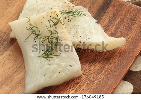 freshness flat fish and green herbal dill weed on wooden plate for cooking image