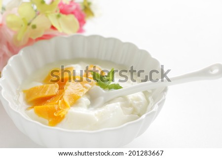 Dried mango and honey on yogurt with flower on background