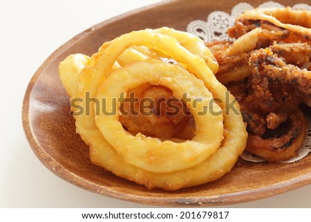 deep fried squid ring calamari and onion ring on wooden plate