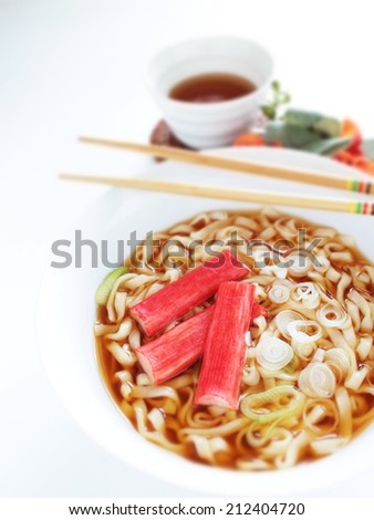 Japanese food, kanikama surimi on instant udon noodles wtih barley tea on background