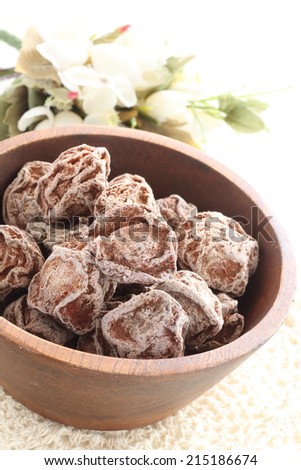 Chinese salty dried plum, Li hing mui on wooden bowl