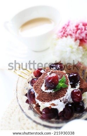 frozen grape on chocolate swiss roll with milk tea on background