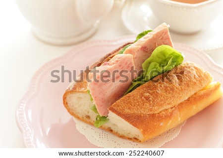 Homemade luncheon meat and lettuce sandwich with English tea on background