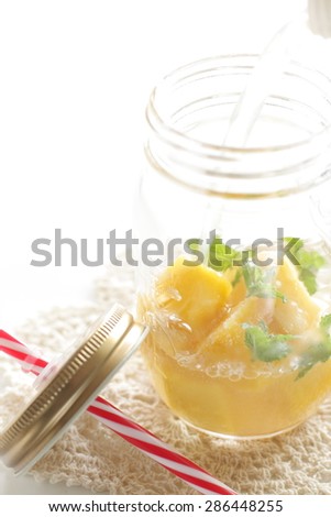 Mango and mint soda cocktail in Jar with Drinking straw