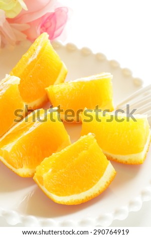 Healthy dessert, orange chopped on dish with flower on background