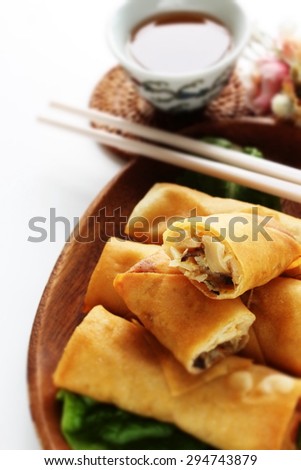 Chinese food, half section spring roll on lettuce with tea on background