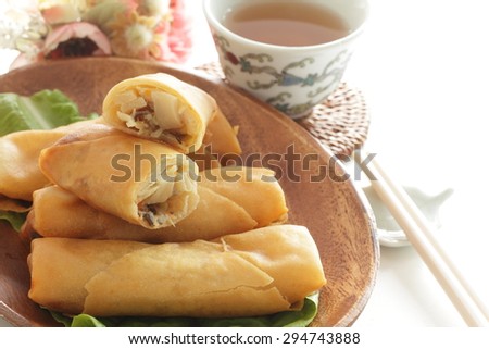 Chinese food, half section spring roll on lettuce with tea on background