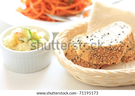 Sesame bread and salad with pasta on background