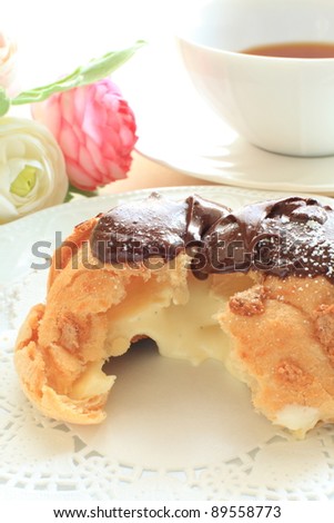 french confectionery, chocolate coating Eclair in half showing the custard cream