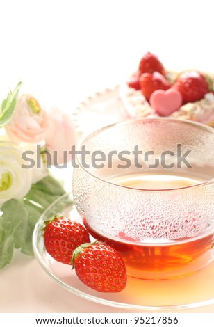Strawberry tea with flower on background