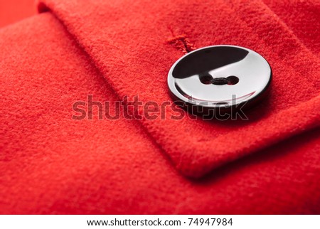 Close-up of button on red coat