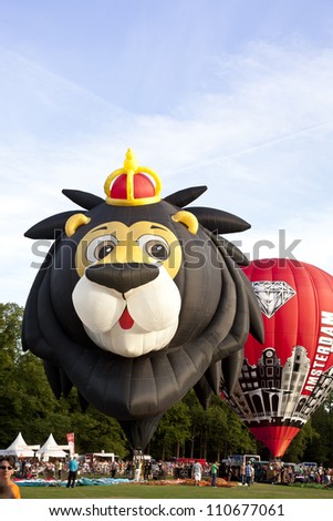 BARNEVELD, THE NETHERLANDS - AUGUST 17:Colorful lion and red air balloons taking off at international balloon festival Ballonfiesta on August 17, 2012 in Barneveld, The Netherlands