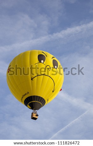 BARNEVELD, THE NETHERLANDS - 17 AUGUST: Colorful yellow balloon with face taking off at international balloon festival Ballonfiesta in Barneveld on August 17, 2012 in Barneveld, The Netherlands