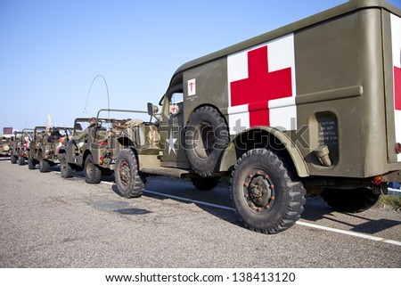 IJMUIDEN, THE NETHERLANDS-MAY 5 : Army trucks of organization Kelly's Heroes riding on beach on May 5,2013 in IJmuiden, The Netherlands. Simulate arrival of allies on liberation Second World War