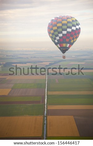 Hot air balloon with green Dutch landscape from above