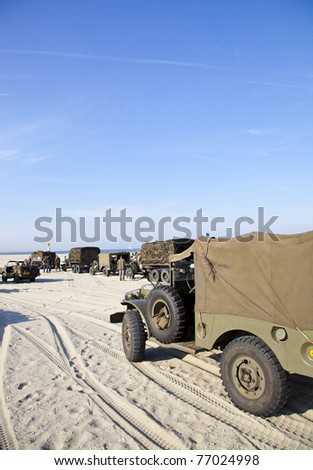IJMUIDEN, THE NETHERLANDS-MAY 5: Army trucks of organization Kelly\'s Heroes riding on beach on May 5,2011 in IJmuiden, The Netherlands. Simulate arrival of allies on liberation Second World War
