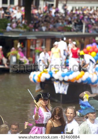 AMSTERDAM - AUGUST 6: People greeting from a boat at Canal Parade at Gay Pride weekend in Amsterdam on August 6, 2011. Gay Pride celebrates equality for gay,lesbian and transgender communities