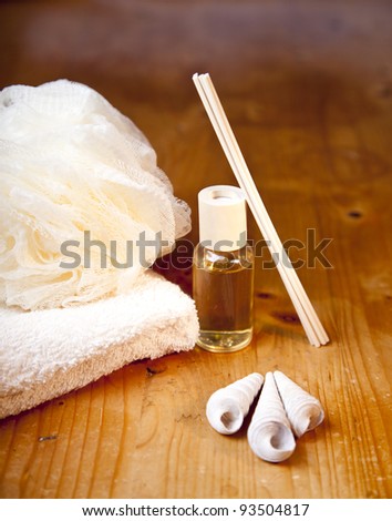 Luxury bath or shower set with towel, sponge, perfume and shells on wooden table