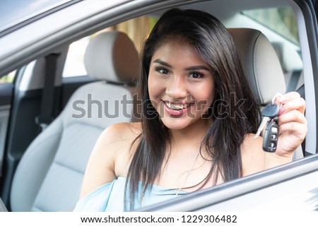 Young hispanic teenage girl learning to drive a car