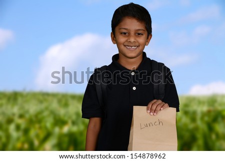 Boy walking to school with his lunch bag