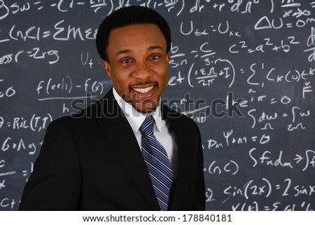 Teacher standing in front of the black board at school