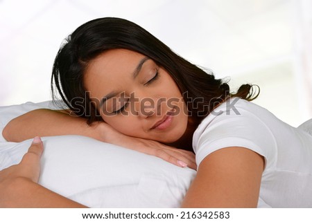 Woman asleep on her bed with a pillow